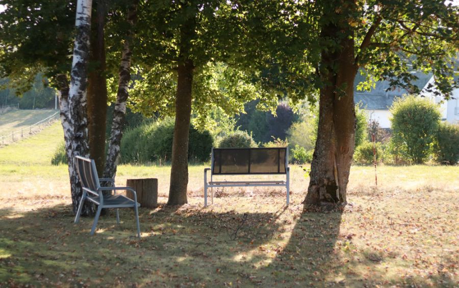 Aussenanlage mit Bänken unter Bäumen