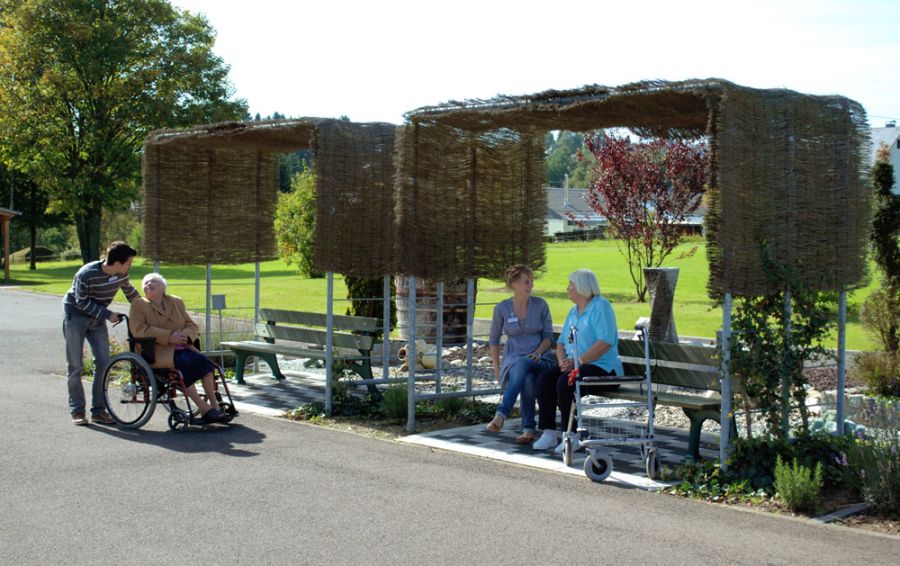 Sonnenschutz über Sitzbänken im grünen