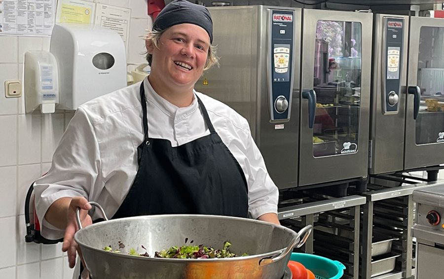 Köchin mit großer Schüssel macht einen Salat