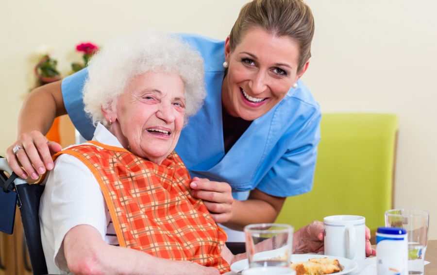 Bewohnerin und Mitarbeiterin beim Frühstück der Bewohner